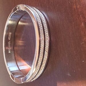 Michael Kors silver-tone hinged bangle bracelet with pavé crystal accents. 